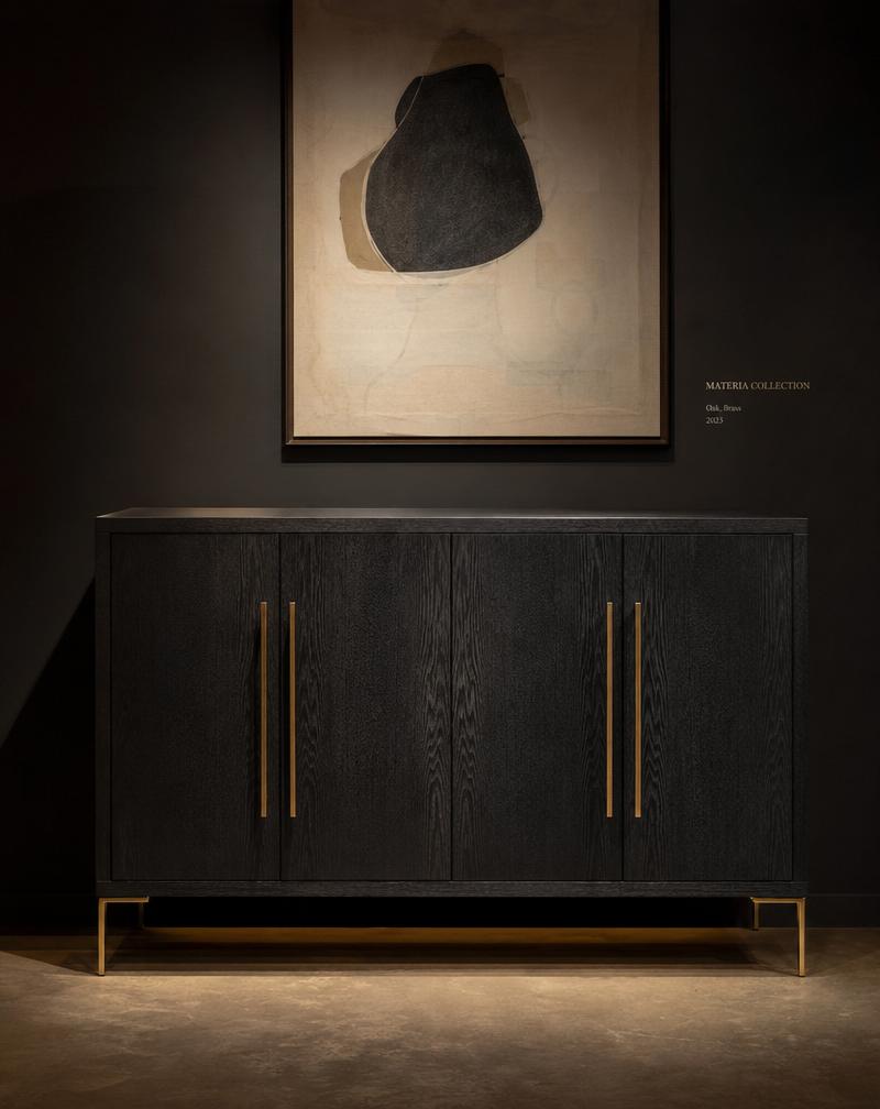 A black ebonized oak cabinet with slender brass handles in a gallery setting.