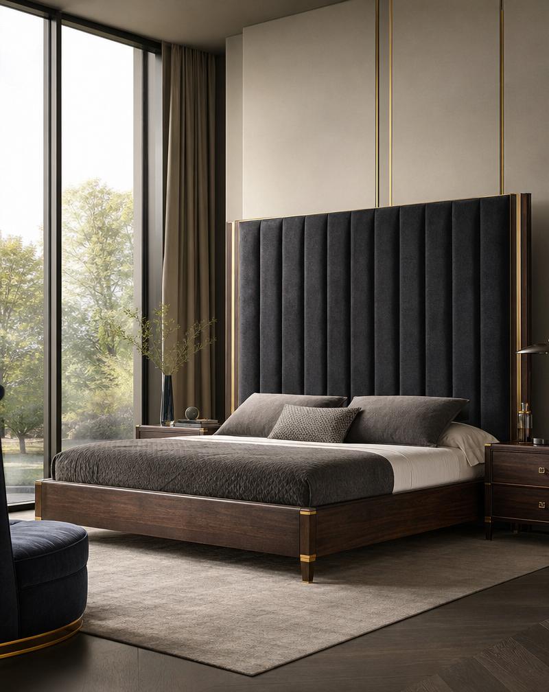 A bespoke bed with a tall charcoal velvet headboard and dark walnut frame in a bright bedroom.